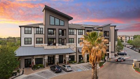 A modern building with a parking lot in front of it.