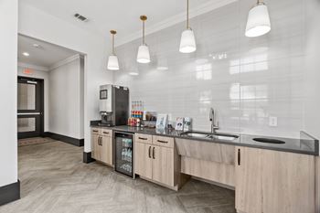 A kitchen with a refrigerator, sink, and cabinets.