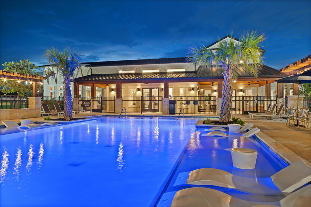 A large swimming pool in front of a house.