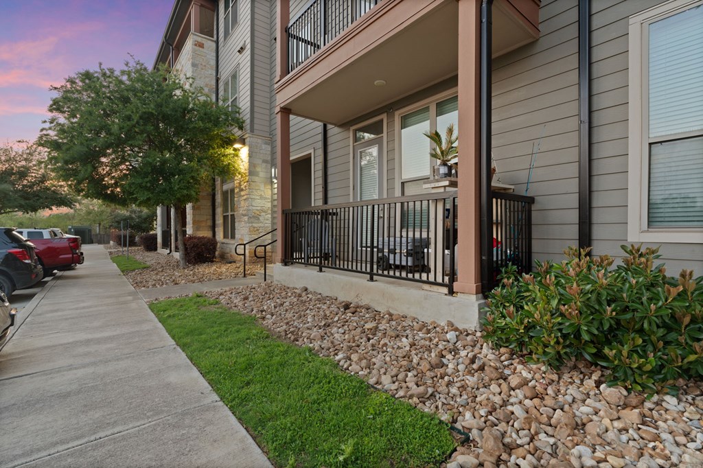 A building with a balcony and a car parked in front.