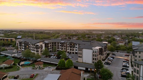 A sunset view of a parking lot and buildings.