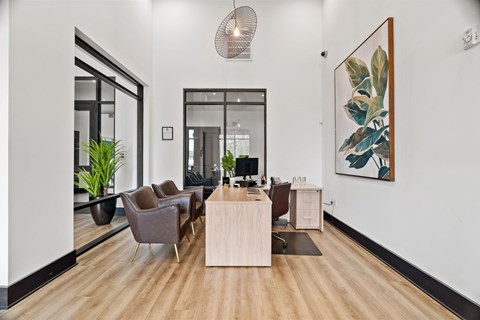 A modern office space with a wooden floor and a large painting on the wall.