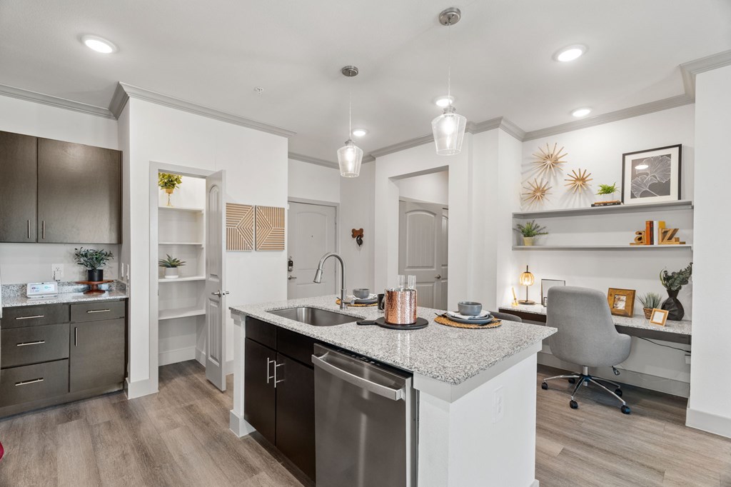 A modern kitchen with a large island and a dining area.