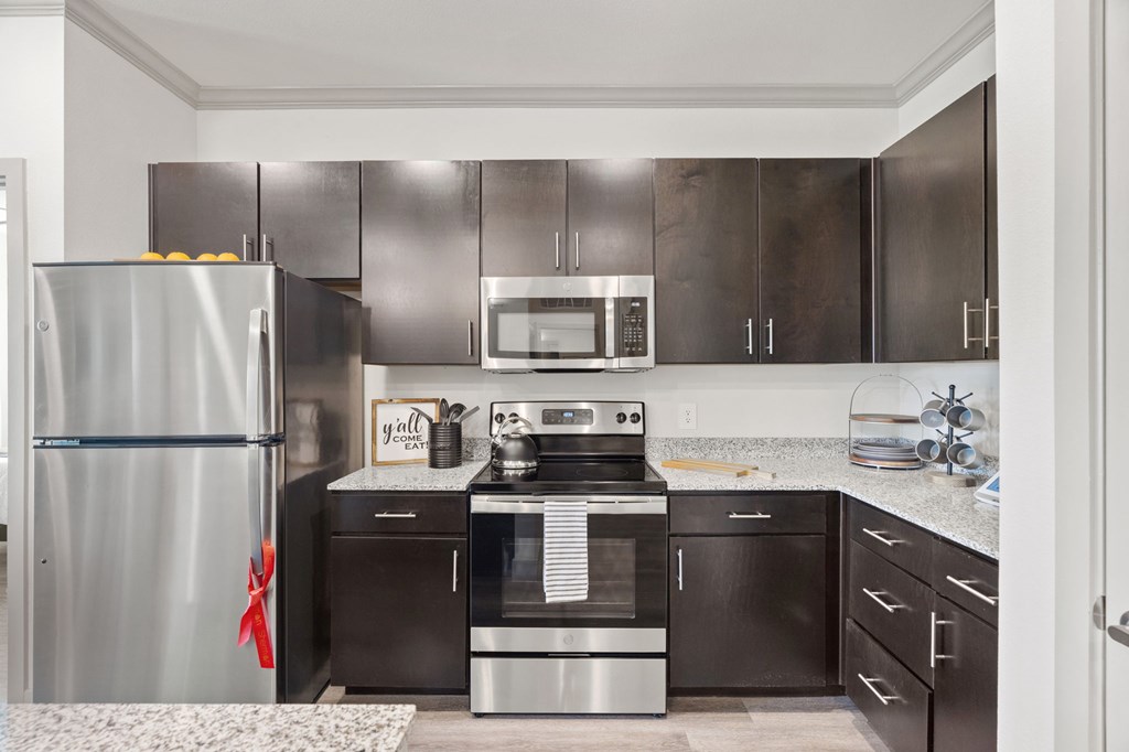 A modern kitchen with stainless steel appliances and a white countertop.