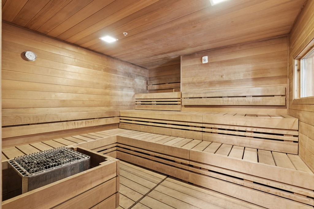a sauna with wooden walls and benches and a window