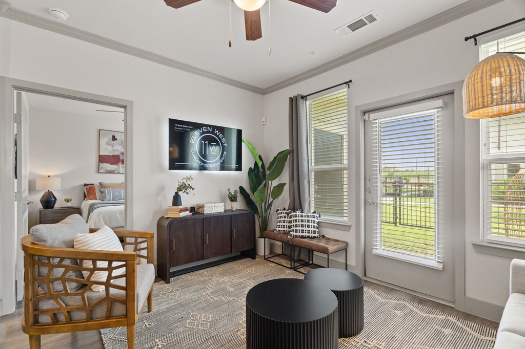 A living room with a wooden chair, a black table, and a ceiling fan.