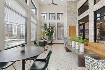 a living room with a large window and a table with chairs