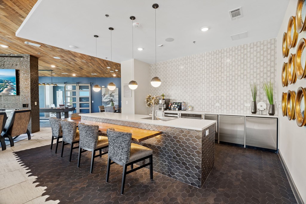 A modern kitchen with a wooden island and grey chairs.