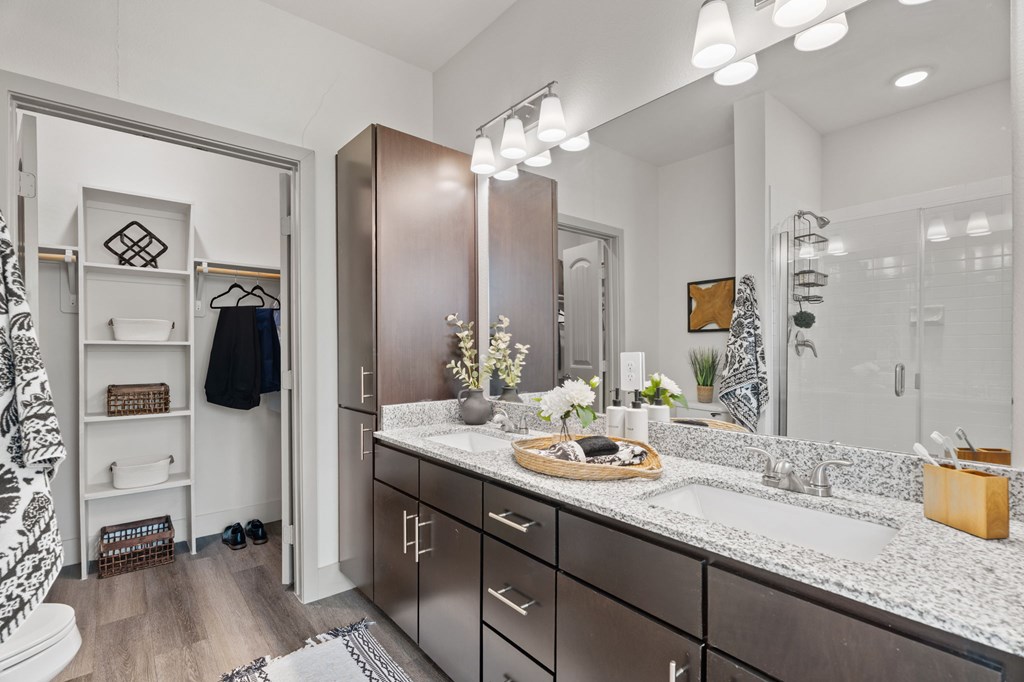 A bathroom with a sink, mirror, and a towel rack.
