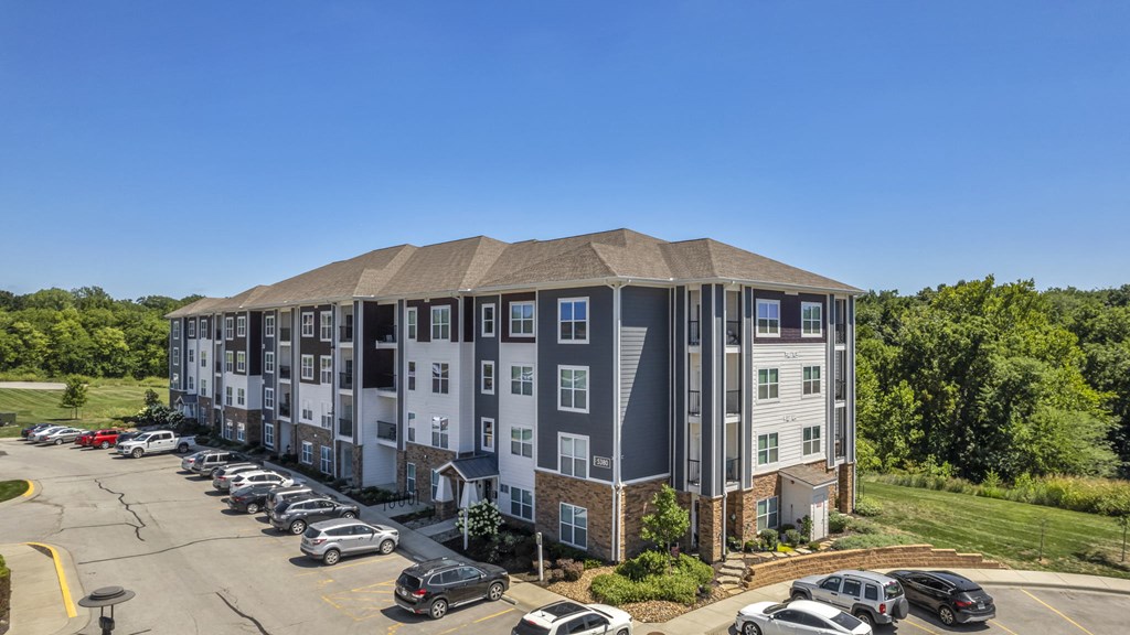 an aerial view of an apartment building with a parking lot
