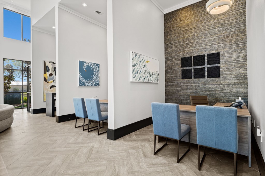A room with a long table and blue chairs.