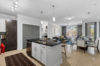 A modern kitchen with dark wood cabinets and a black countertop.