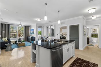 A modern kitchen with a black countertop and stainless steel appliances.