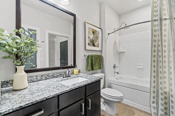 A bathroom with a toilet, sink, and shower.