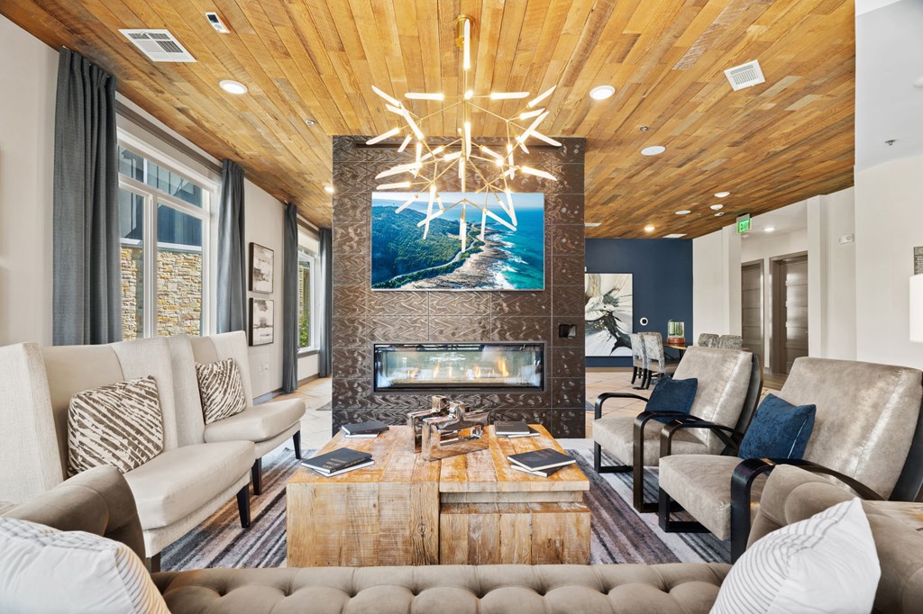 A modern living room with a fireplace and a large painting above it.