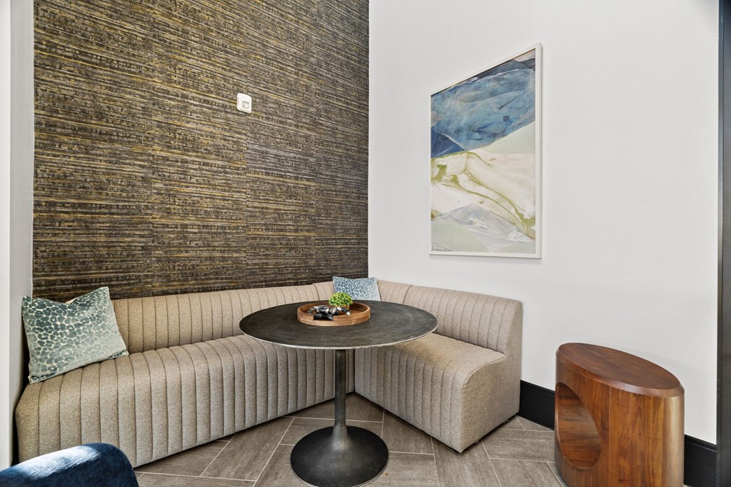 A round table with a plant on it sits between two couches in a room.