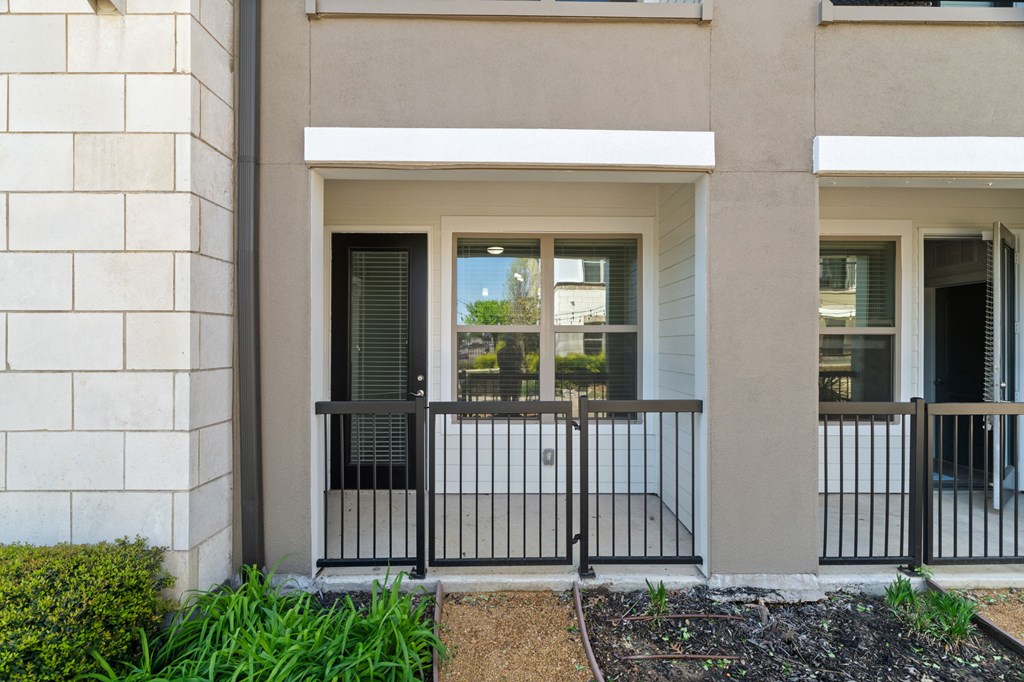 A house with a black gate and a brown fence.