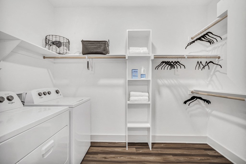a small laundry room with a washer and dryer and shelves
