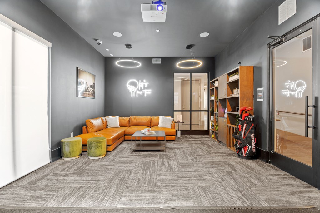 A modern office space with a grey carpet and a grey wall with a white light bulb decoration.