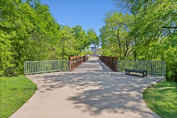 A bridge with a metal railing and a bench on the side.