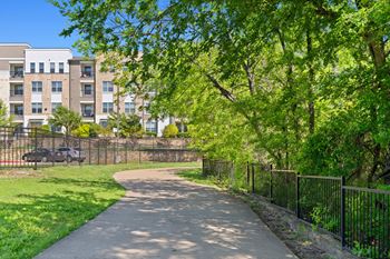 A tree-lined walkway leads to a building.