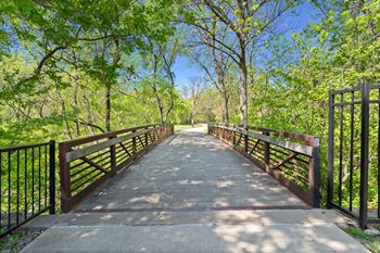 A bridge with a metal railing and a wooden handrail.