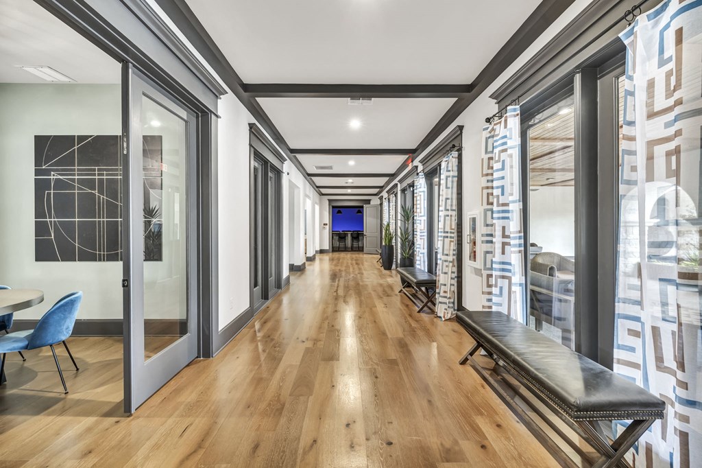 a long hallway with glass doors and windows and a wood floor