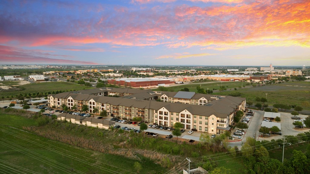 A large apartment complex is shown with a parking lot in front.