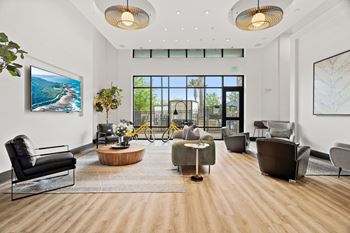 A spacious living room with a view of the outdoors through a large window.