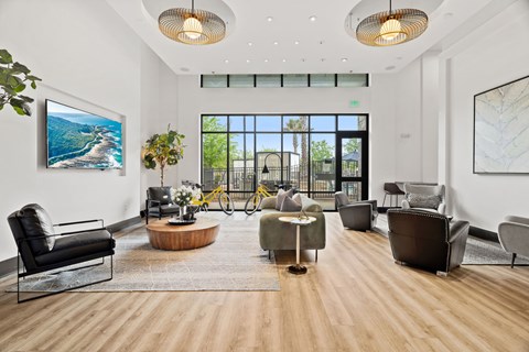 A spacious living room with a view of the outdoors through a large window.
