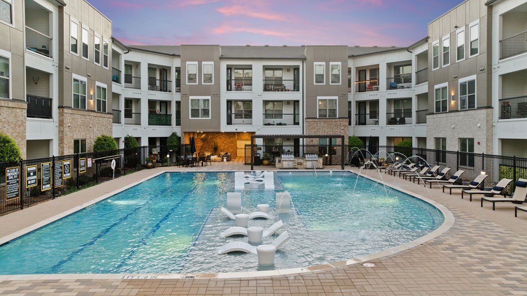 A large swimming pool in the middle of a courtyard surrounded by apartment buildings.