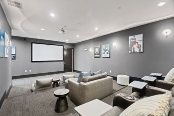 A modern living room with a grey carpet and a large couch.