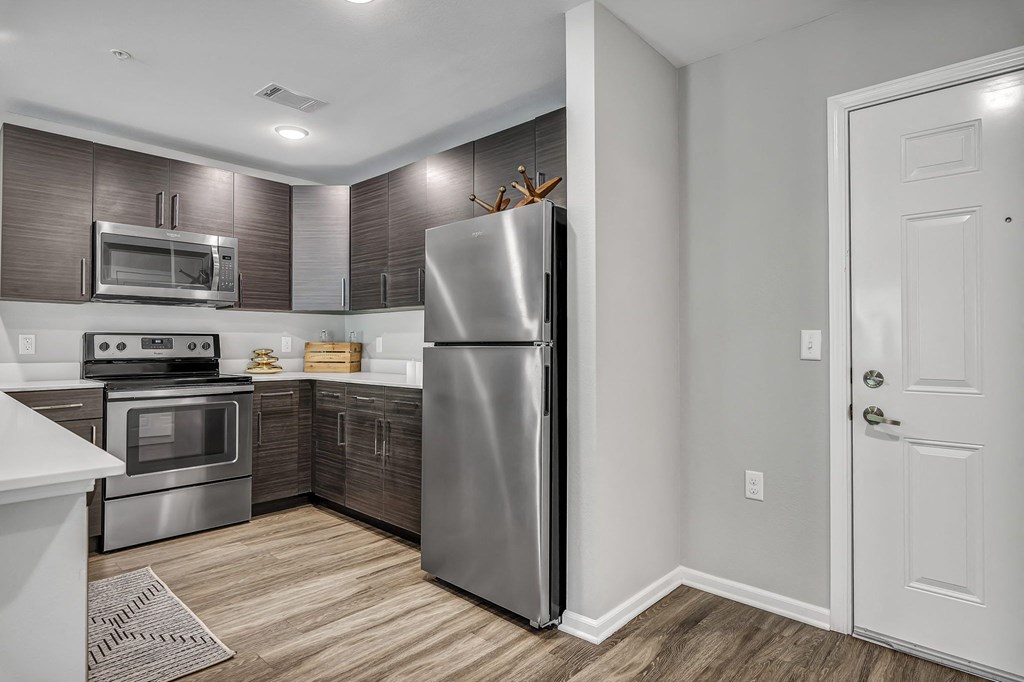 a kitchen with stainless steel appliances and wooden floors