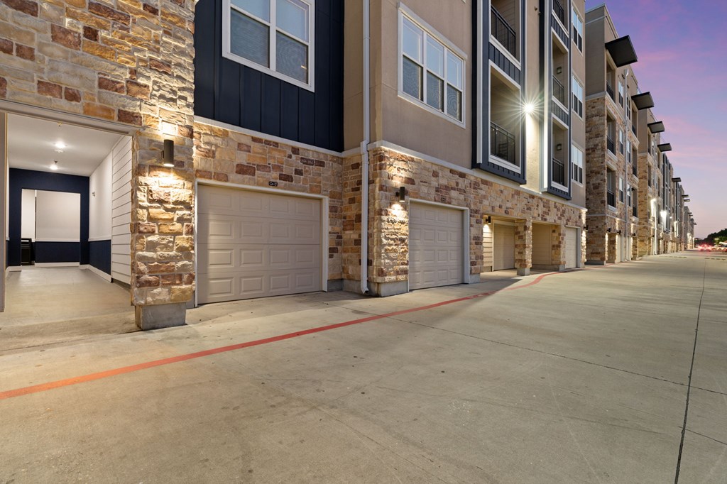 A row of townhouses with garages and stone pillars.