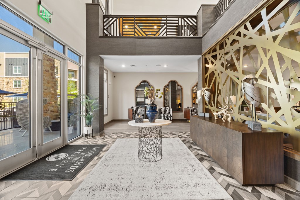 A lobby with a black and white rug and a wooden reception desk.