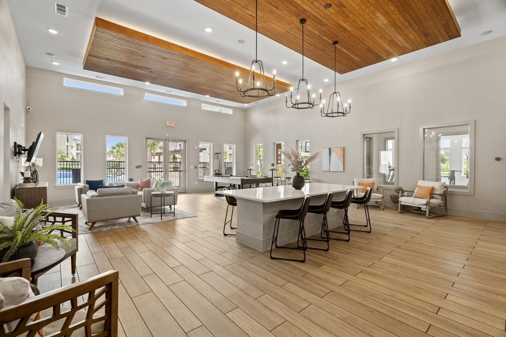 A spacious living room with a kitchen area in the background.