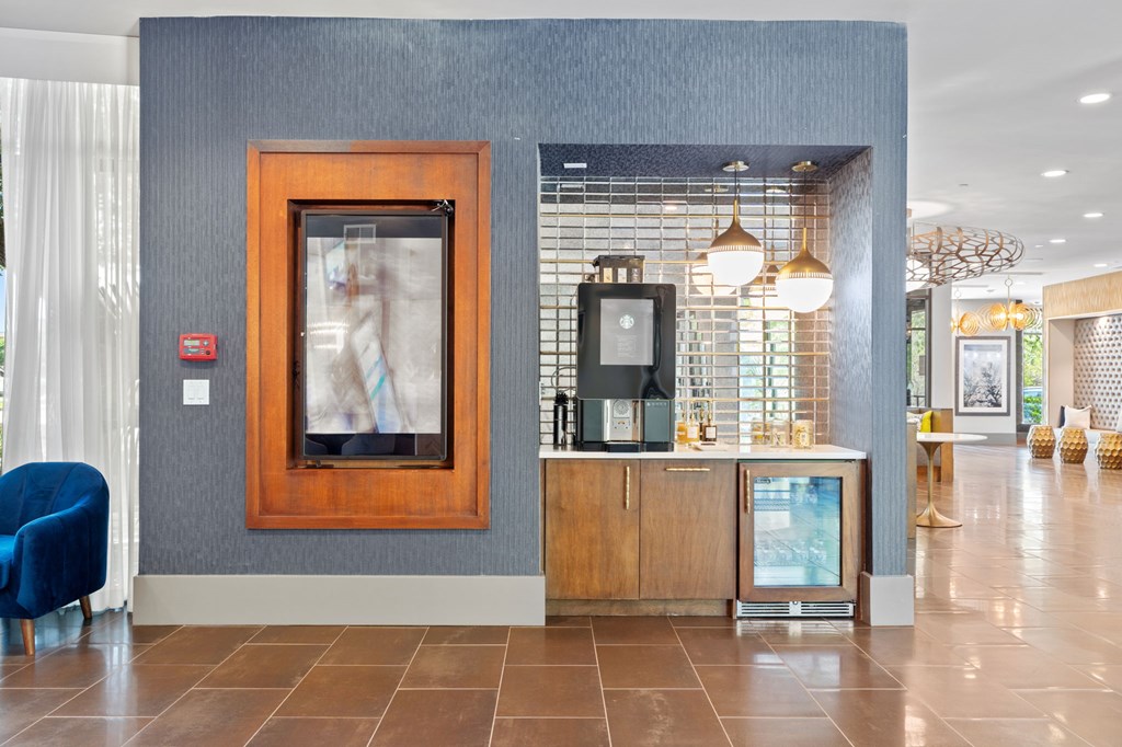A reception area with a blue chair and a framed picture on the wall.