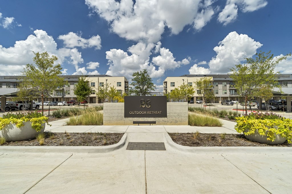 a monument in front of a building with trees and plants