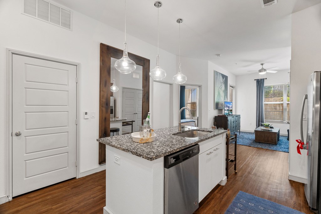 A kitchen with a granite countertop and stainless steel appliances.