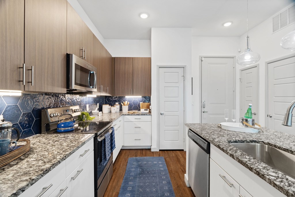 A kitchen with white cabinets and a granite countertop.