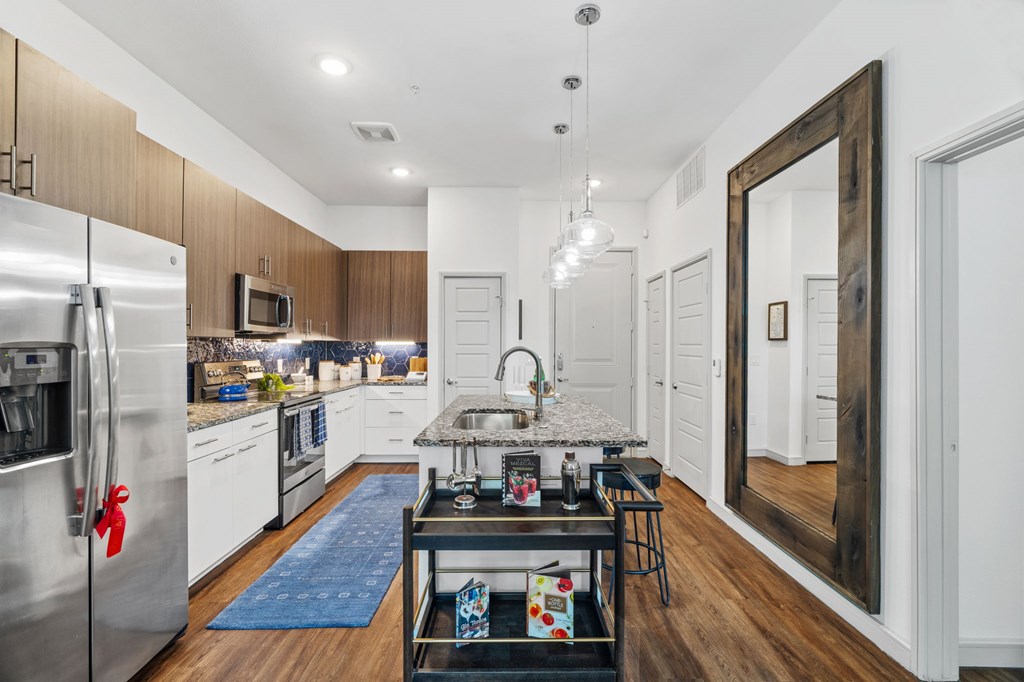A modern kitchen with a blue rug on the floor.