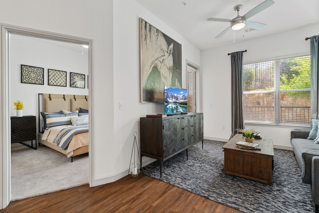 A bedroom with a bed, dresser, and a painting on the wall.