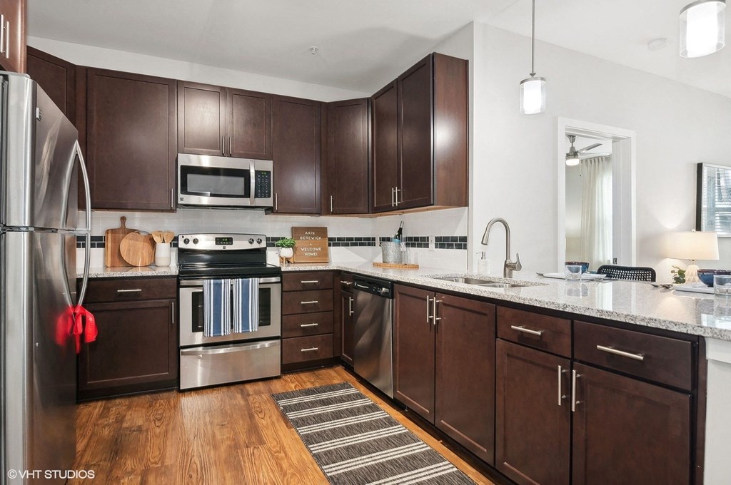 a large kitchen with wooden cabinets and stainless steel appliances