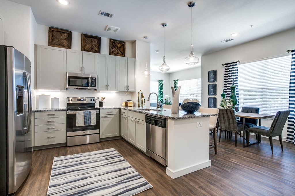 an open kitchen and dining area with stainless steel appliances and a window
