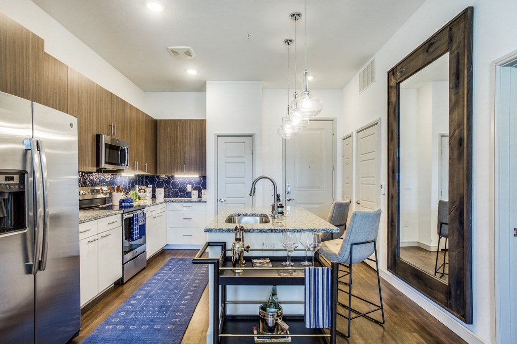 a kitchen with stainless steel appliances and a marble counter top