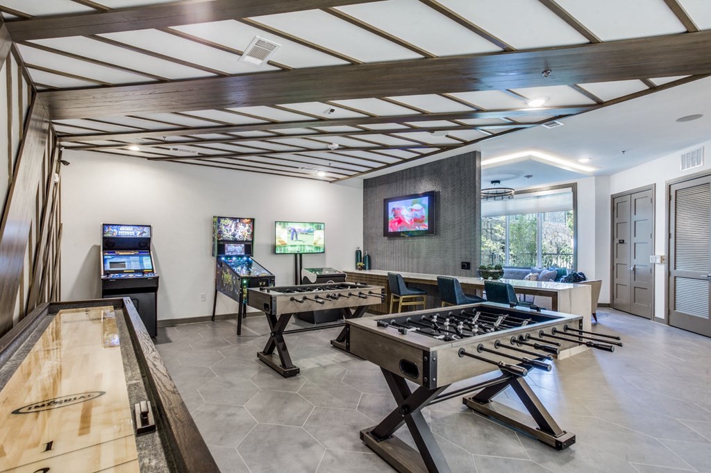a game room with a foosball table and two game systems