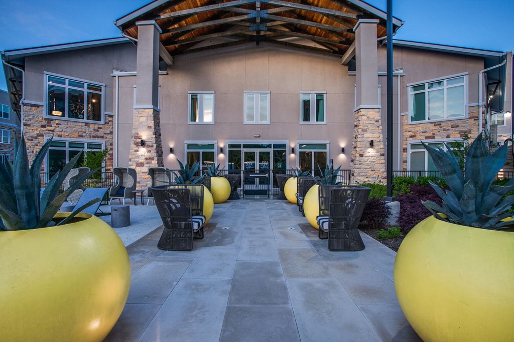 a patio with tables and chairs in front of a building
