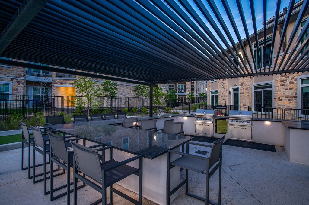 an outdoor patio with tables and chairs and a building in the background