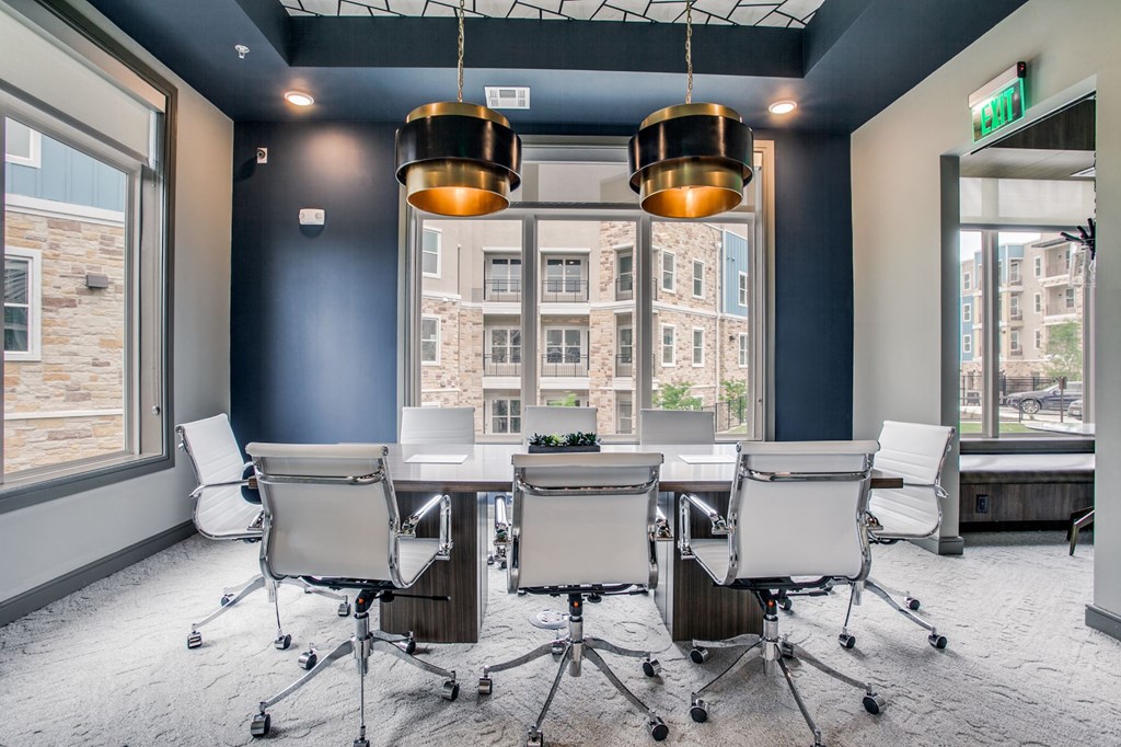 a conference room with a table and chairs in front of a window