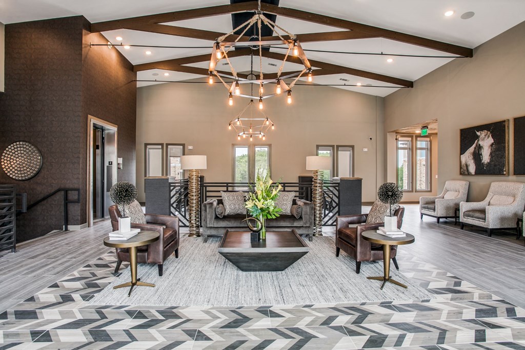 a large living room with a geometric rug and a chandelier